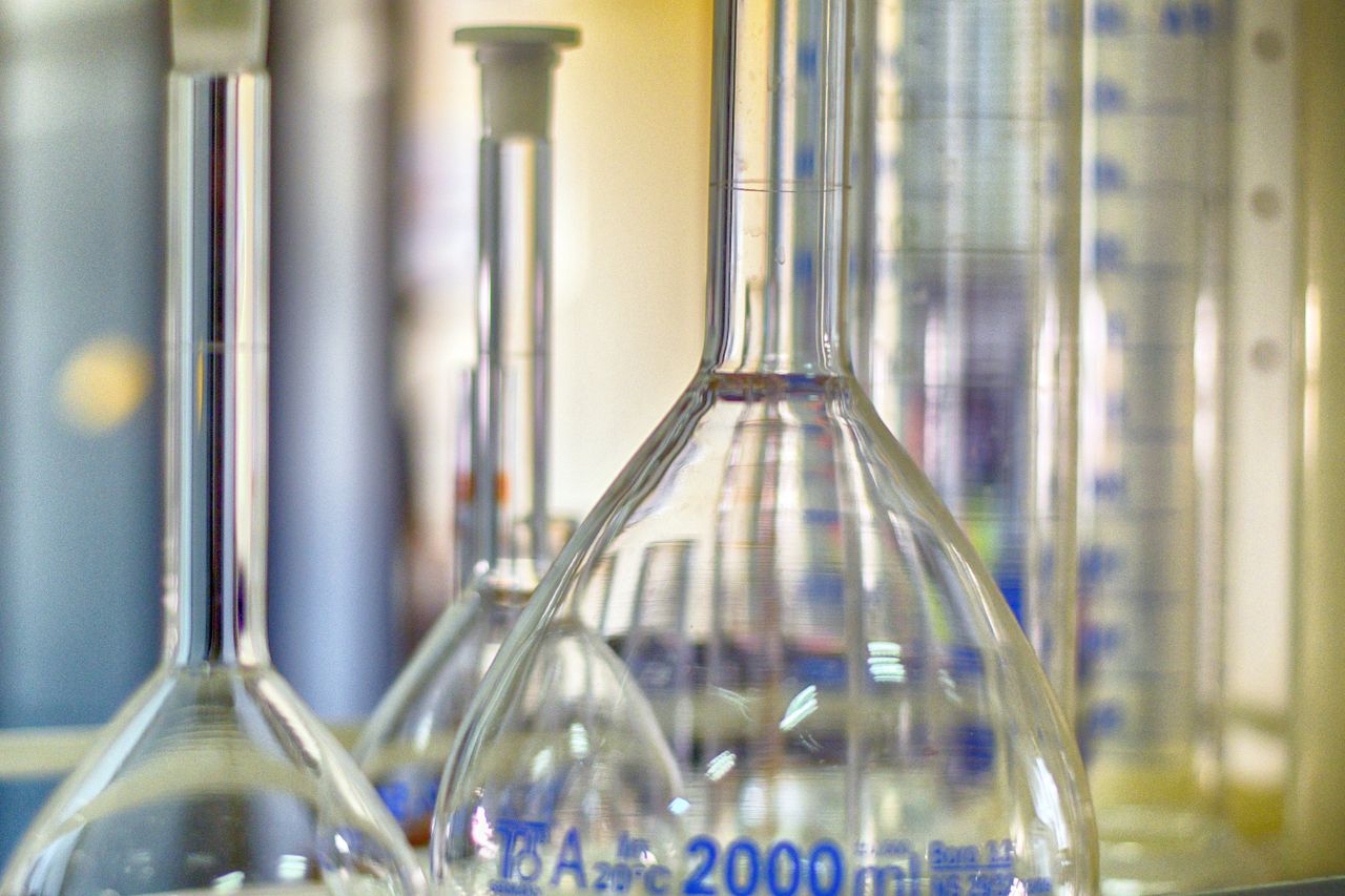 Home Closeup of various glass transparent chemistry flasks placed on table in modern laboratory
